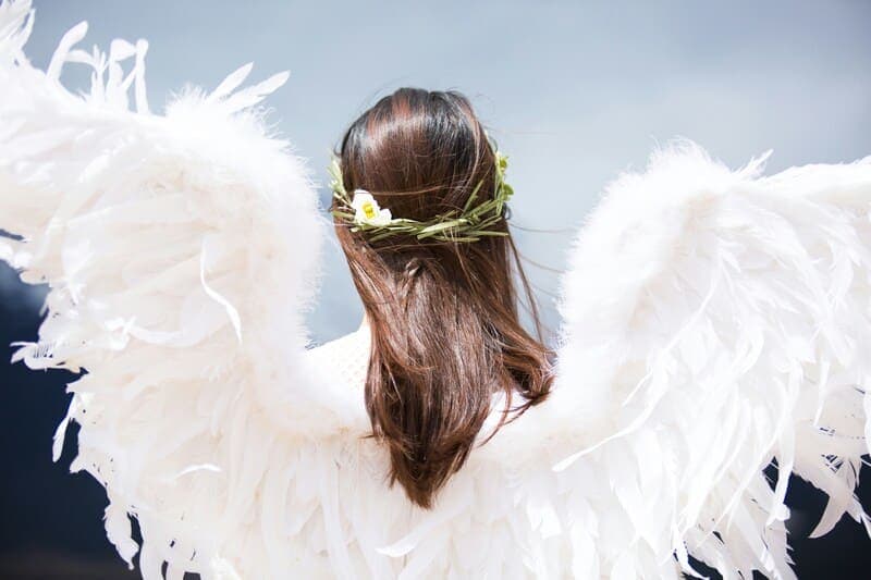 A woman wearing a white angel symbolizing the concept of angelic guidance and spiritual messages