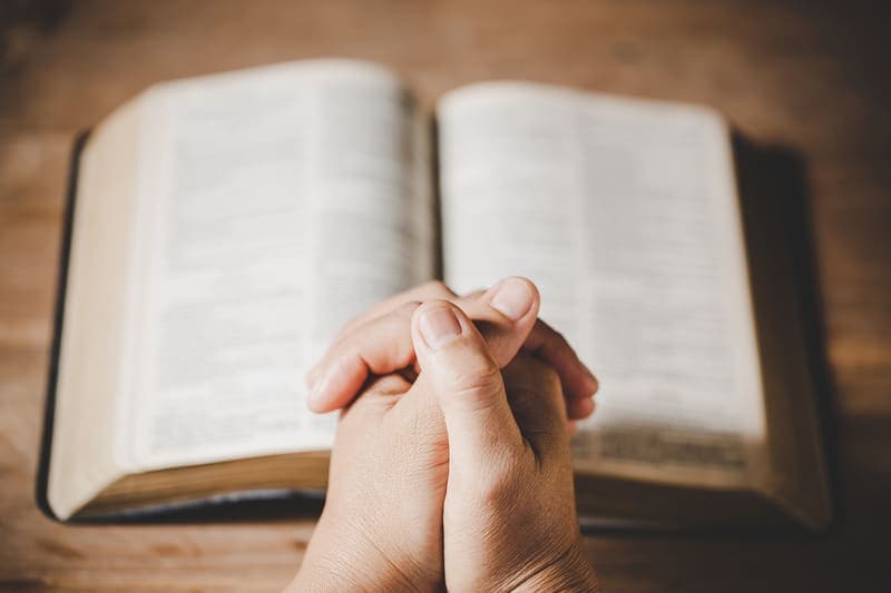 the bible opened for a person who is reading psalm 49 and praying