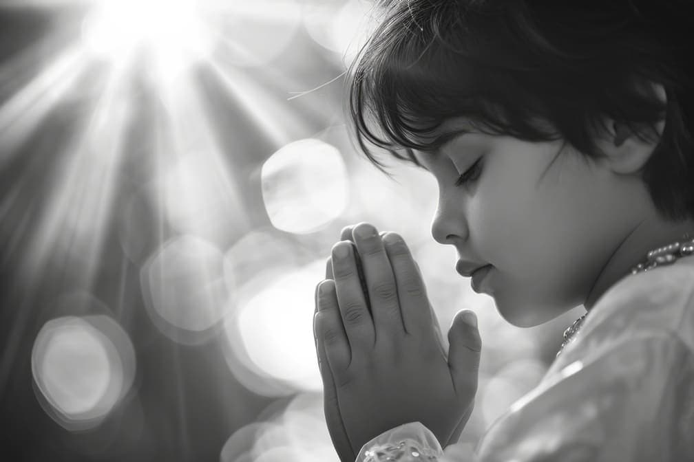 A boy praying in the church with sunlight shining on him